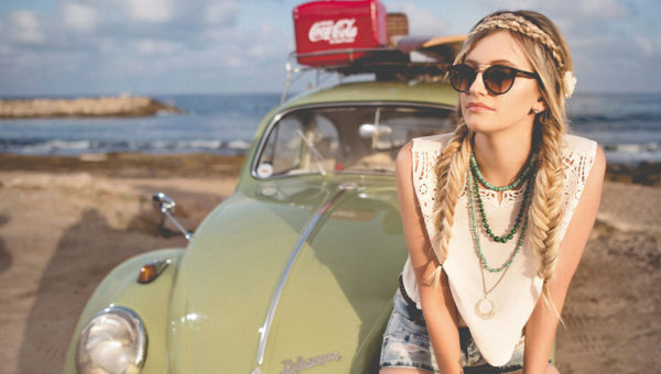 Femme portant une tenue bohème avec lunettes de soleil au bord de la mer