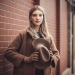 Femme portant un manteau de créateur avec chapeau dans un style chic